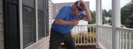 Man hunched over to one side as if holding off the wind