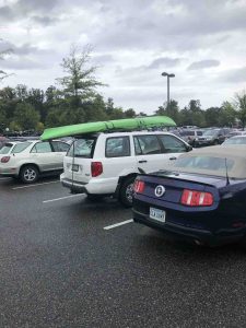 Kayak on top of car at super market before storm