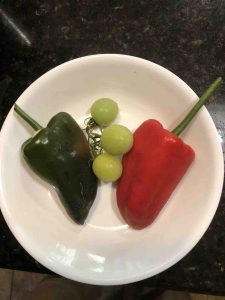 picture of two peppers and there cocktail green tomatoes